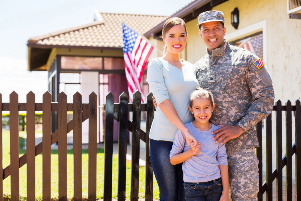 Military family standing in front of new home